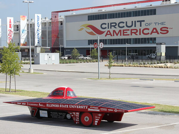 Solar car from Illinois State University parked in front of the Circuit of the Americas building.