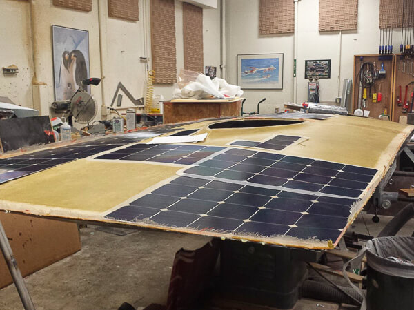 Workshop scene with a large flat surface covered in solar panels.