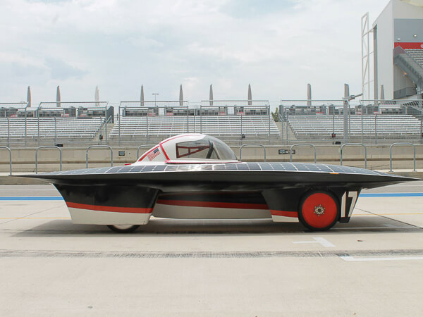 A solar-powered car with solar panels, red details, and the number 17 on the side.